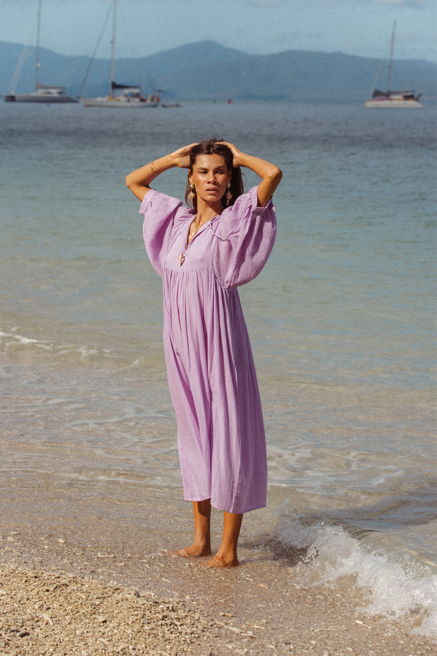 Daughters of India Kyra Midi Dress in Lilac Gauze — full length on beach with sailboats, billowed sleeves, cotton gauze