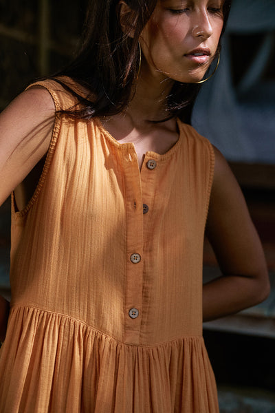 Nadi Dress Amber — bodice close-up showing wooden button front detail, amber double gauze cotton fabric texture with gathered waist, artisan India | Daughters of India